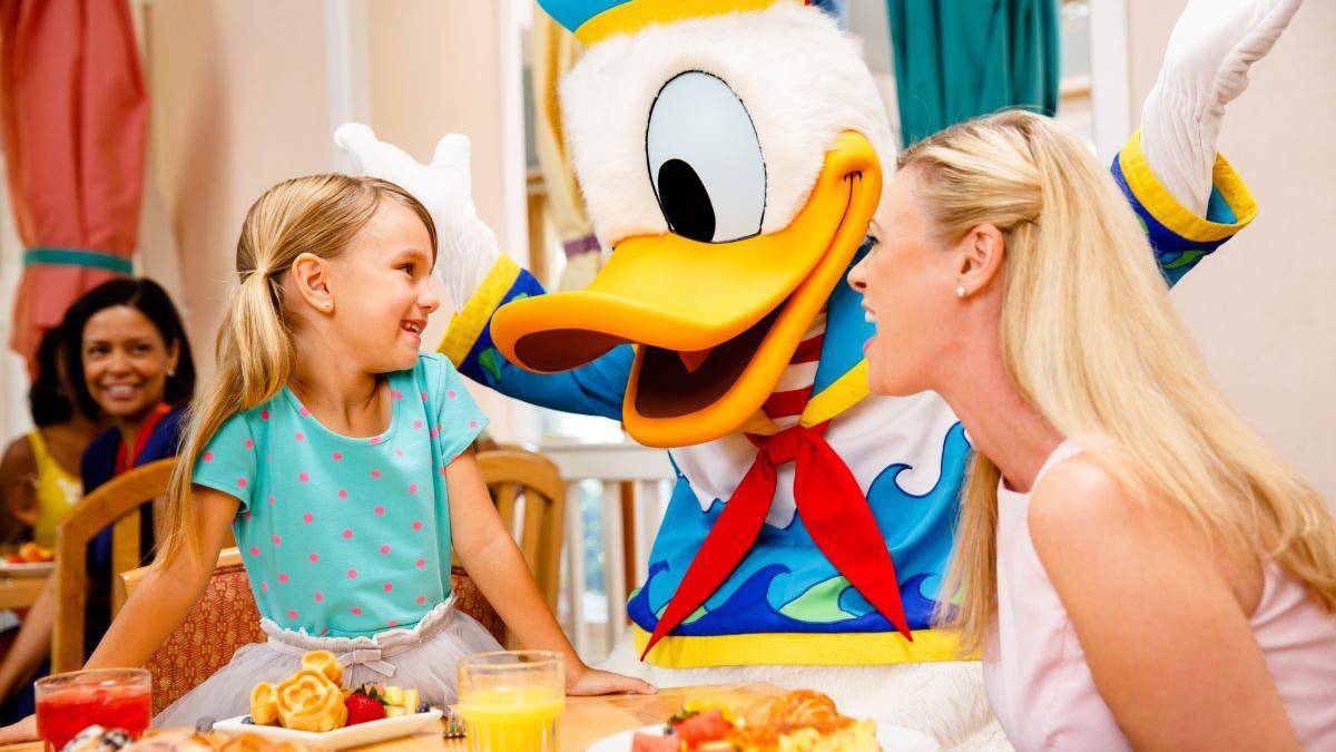 mother and daughter having breakfast with donald duck at Disney's Beach Club Cape May Cafe character breakfast in Orlando, Florida, USA